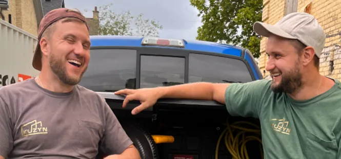 Kuzyn cousins smiling while leaning on a truck